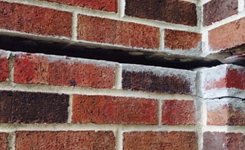 Image of a brick foundation that is bowing due to settlement. Airlift has foundation repair options available to help. 
